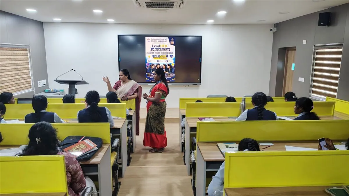 Two organisers introducing the HR Quiz in the smart classroom, with the quiz poster on the screen